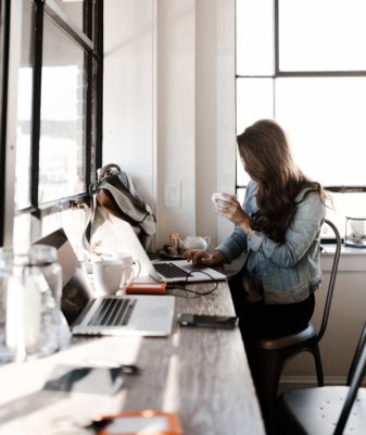 Woman working with a coffee in her hand